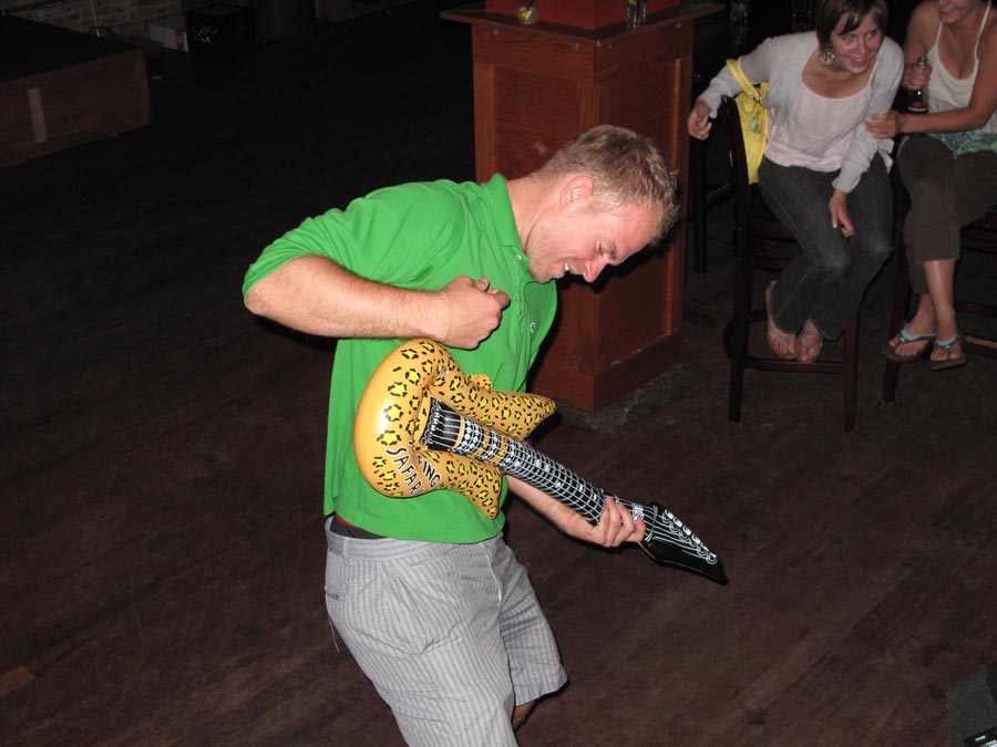 person playing toy guitar at pub