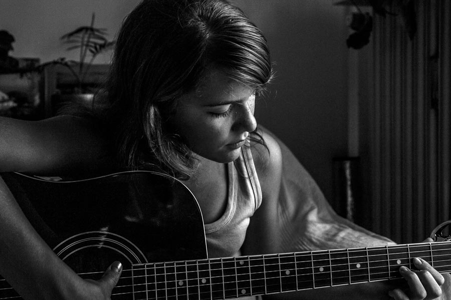 black and white photo of girl playing guitar